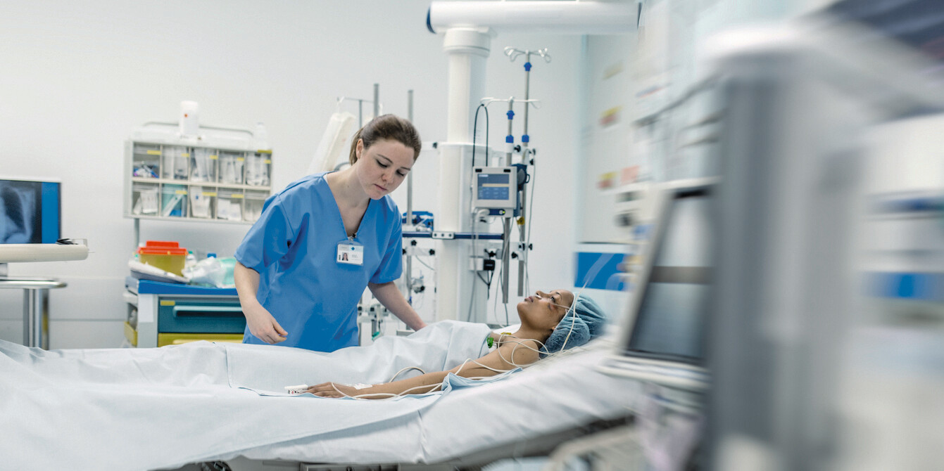 Krankenschwester am Patientenbett mit Beatmungstechnik