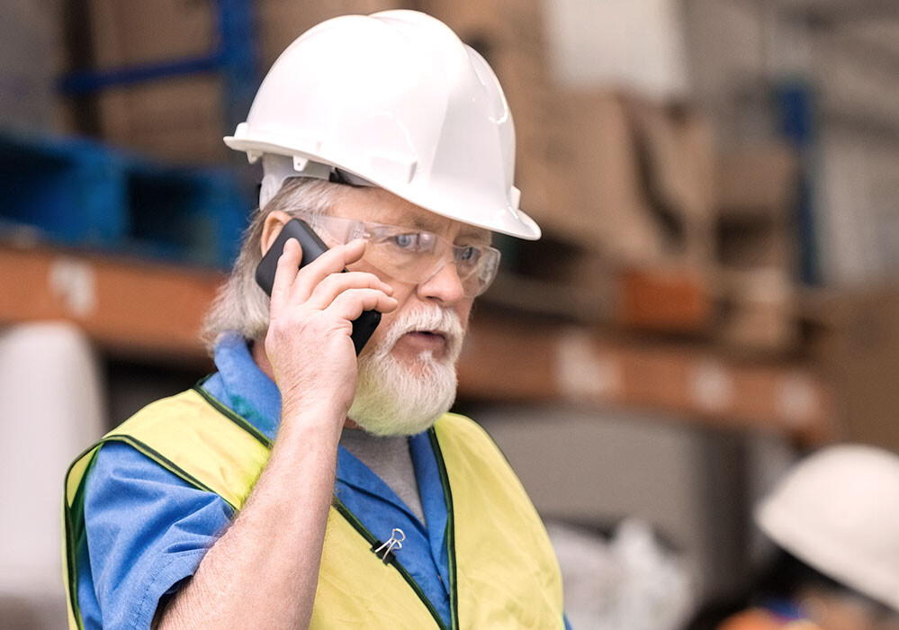 Gewinnen Sie Einblicke in die Leistung Ihres Kompressors Mann in einem Lager am Telefon